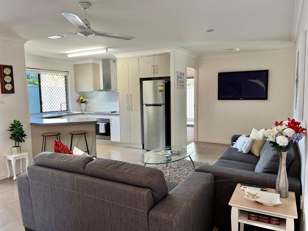 班达伯格Home away from home - Modern luxury in central Bundaberg的一间带两张沙发的客厅和一间厨房