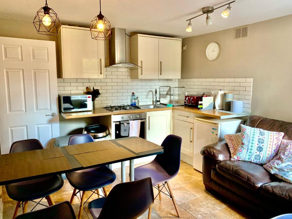 卡迪夫Central City Garden Apartment的厨房以及带桌子和沙发的客厅。