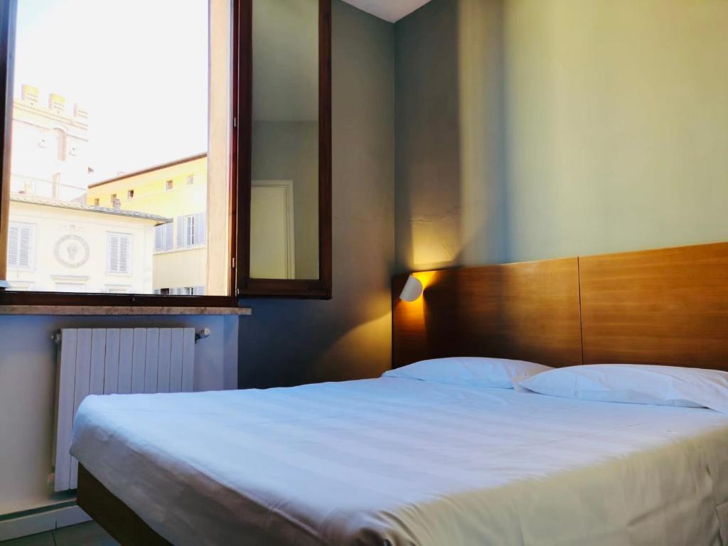锡耶纳拉珀拉酒店的一间卧室设有一张大床和一个大镜子