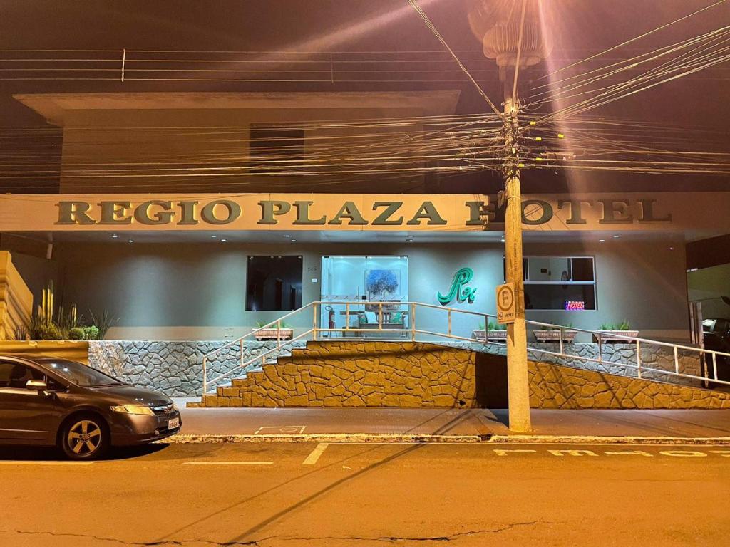 欧里尼奥斯Regio Plaza Hotel的晚上在arizoco广场酒店前停车