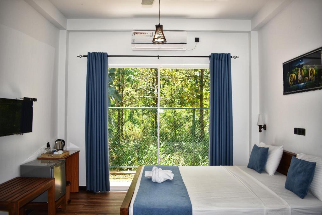 达瓦拉维Forest Edge Safari Villa的一间卧室设有大窗户和蓝色窗帘