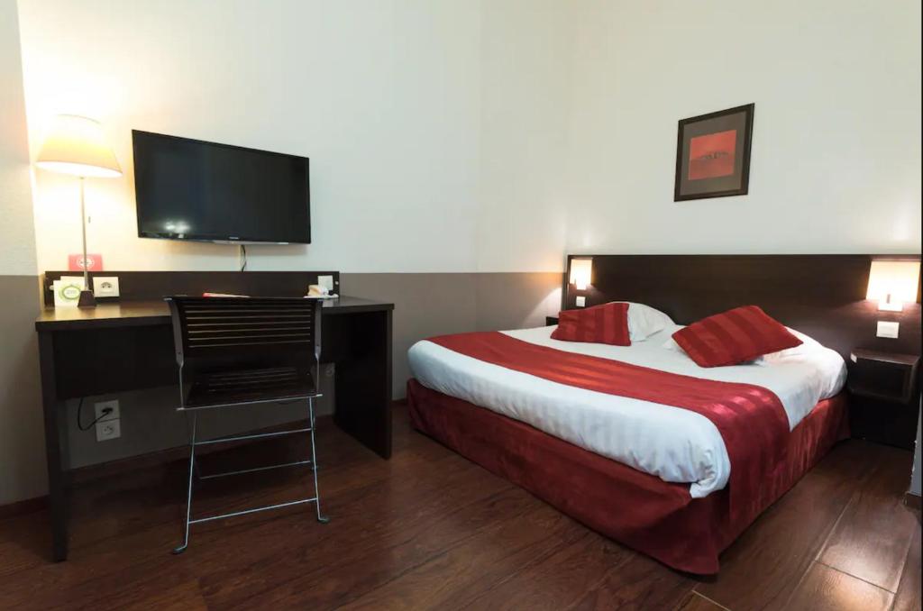 里昂Appart'City Classic Lyon Part-Dieu的酒店客房配有一张床和一张书桌及一台电视