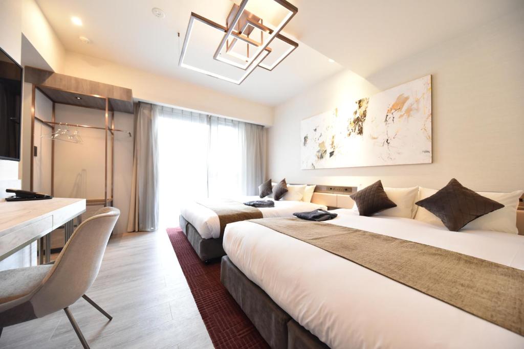 大阪Hotel Cordia Osaka Hommachi的酒店客房配有两张床和一张书桌