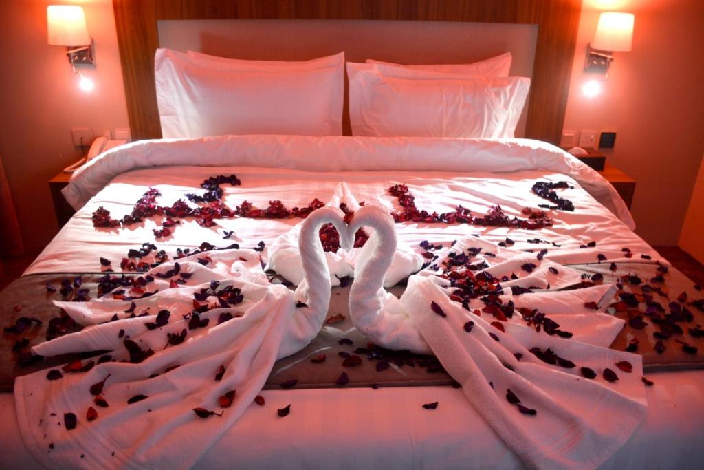 麦地那Salsbil Almasi Hotel的床上两个由心灵制成的天鹅