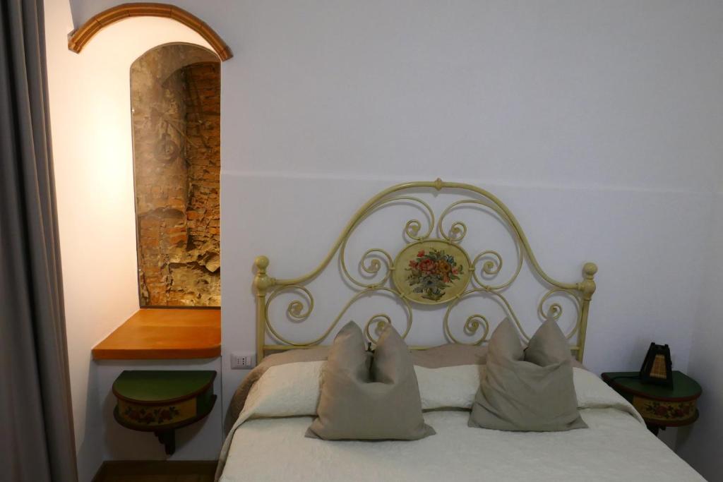 普拉托Appartamento Antico Pozzo的卧室配有白色的床和2个枕头