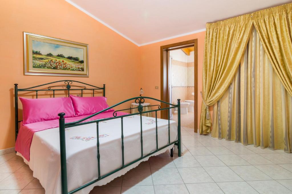 卡布拉斯Casa Titti的一间卧室配有带粉红色枕头的床