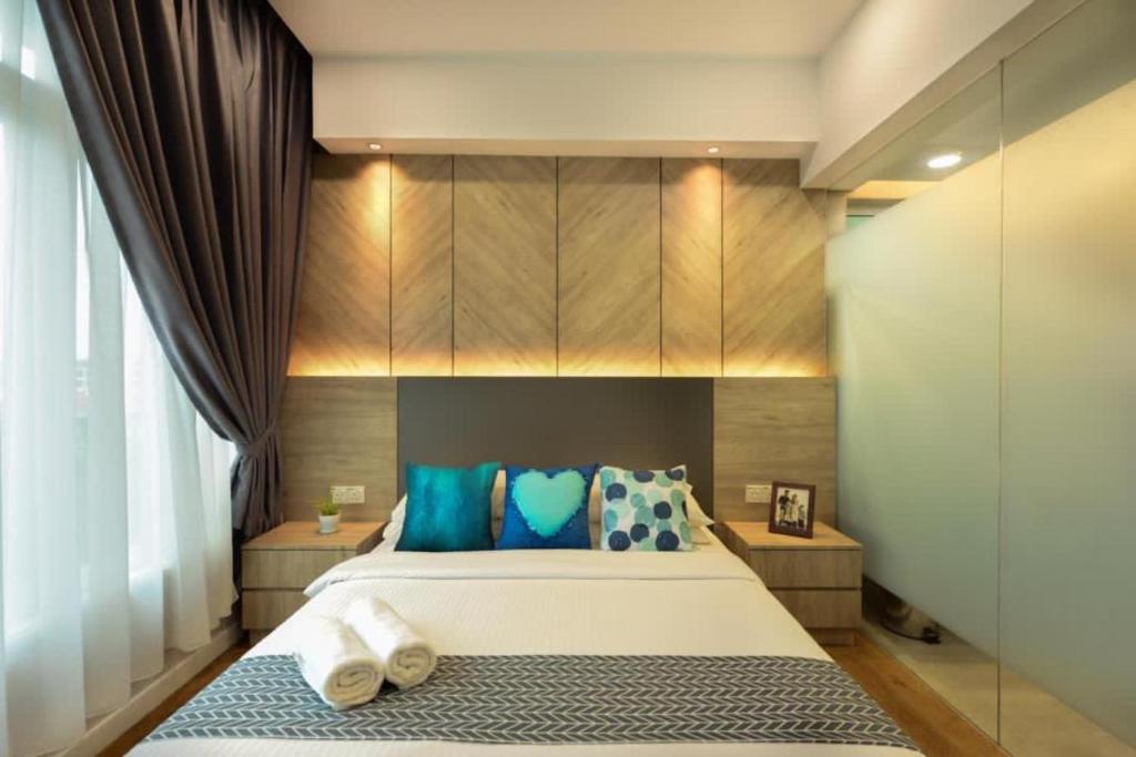瓜埠Designer Suite Apartment Seaview 10pax Families Suite的一间卧室配有一张带蓝色枕头的大床