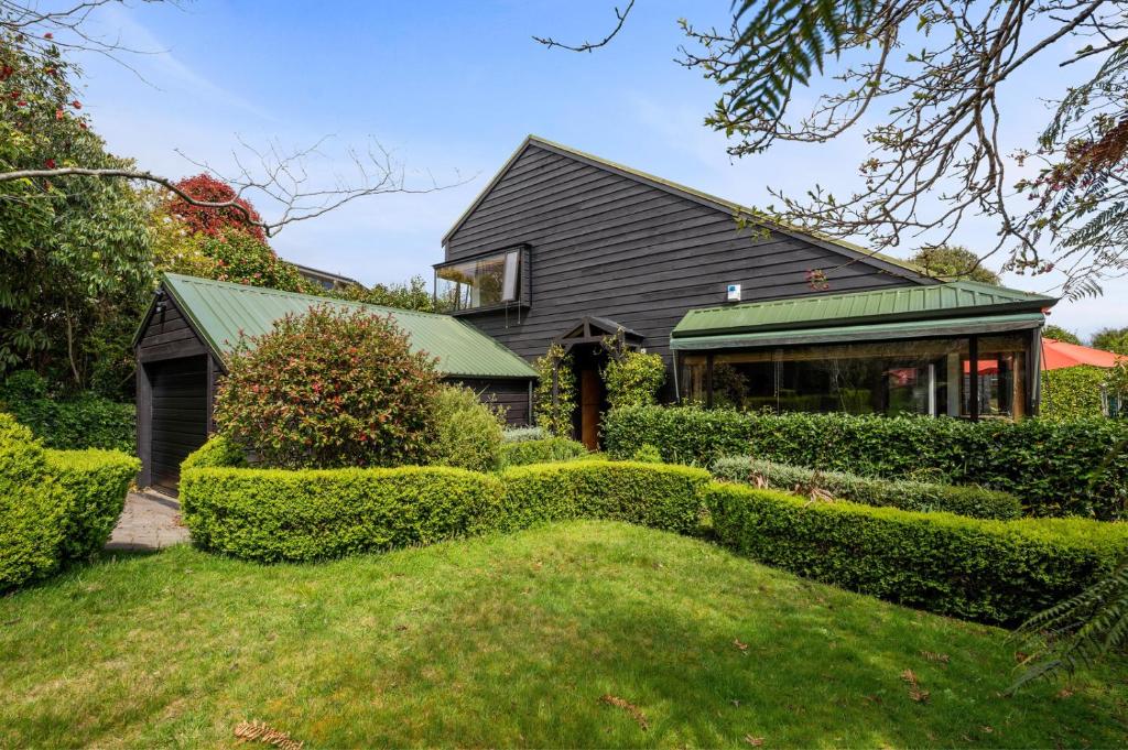 陶波Garden Grove - Taupō Holiday Home的绿色屋顶和灌木的房子