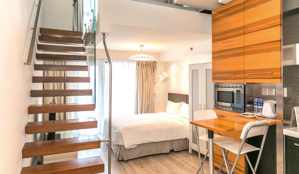 上海上海品尊辉盛名致精品酒店公寓的一间卧室配有一张床、一张书桌和一个楼梯