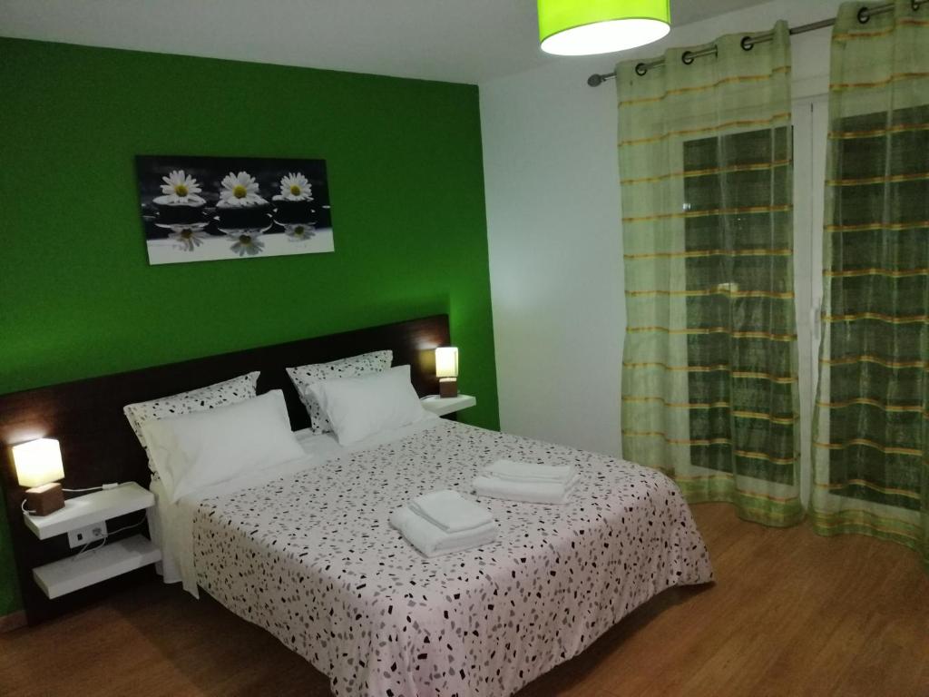 Cortes do MeioCasa do Adro - Serra da Estrela的绿色卧室,配有床和绿色的墙壁