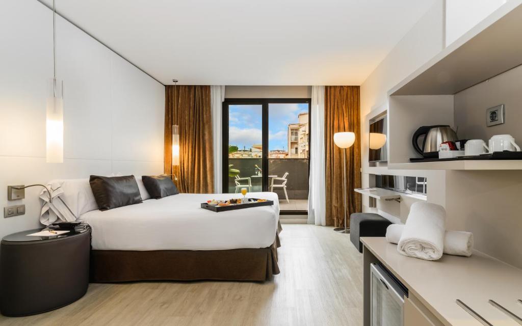 巴塞罗那Grums Hotel & Spa的酒店客房设有一张床和一个大窗户