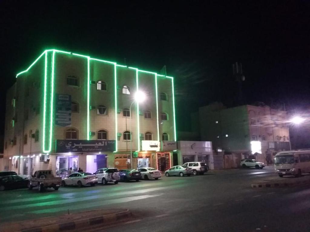 哈伊勒العييري للشقق المفروشة حائل 4的建筑的一侧有绿灯