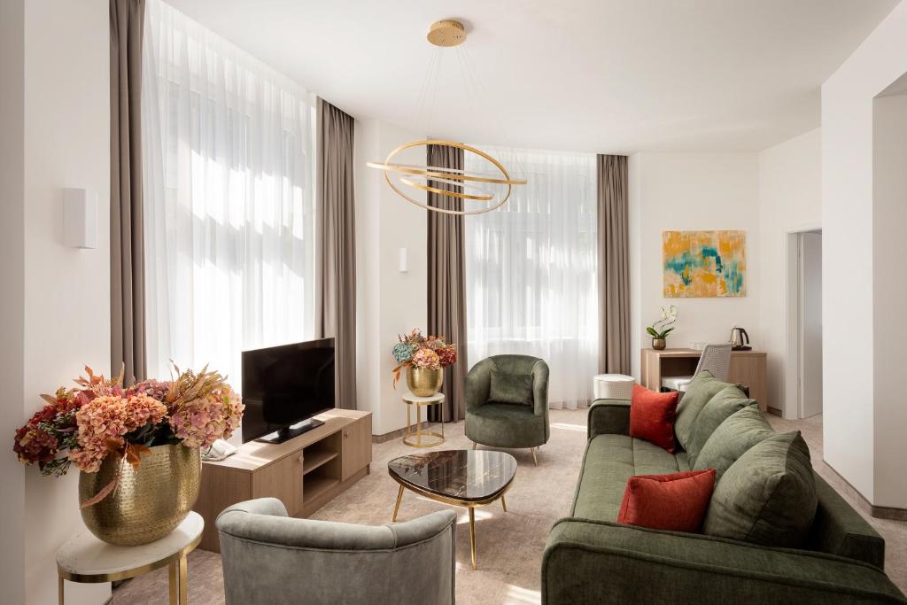 布达佩斯Mera Hotel的客厅配有绿色沙发和椅子