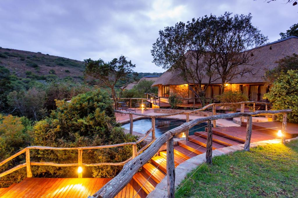 帕特森Lalibela Game Reserve Mark's Camp的一座有桥的房屋,在河上,有灯光