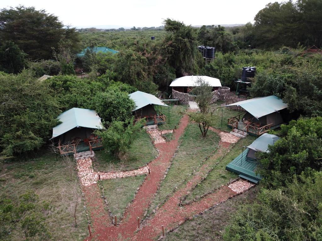 塔勒克Greenwood safari camp的享有花园的空中景致,配有桌子和遮阳伞