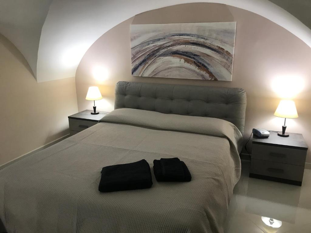 卡塔尼亚Donizetti House的一间卧室,配有一张带两个黑袋的床
