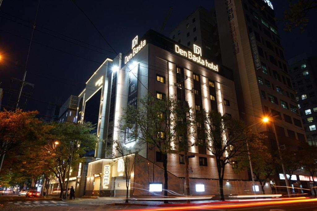 釜山Denbasta Hotel的一座晚上有标志的建筑