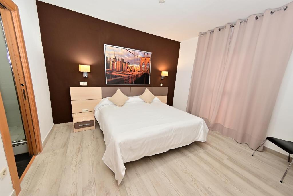 马德里伐尔费斯旅馆的卧室配有白色的床和墙上的绘画作品