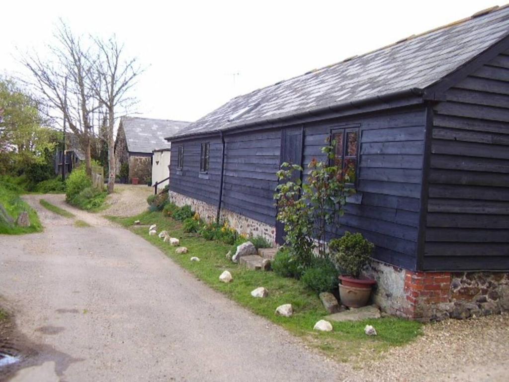 BrighstoneSycamores Barn - Detached, Private, Secluded Country Retreat的蓝色房子,旁边还有一条路