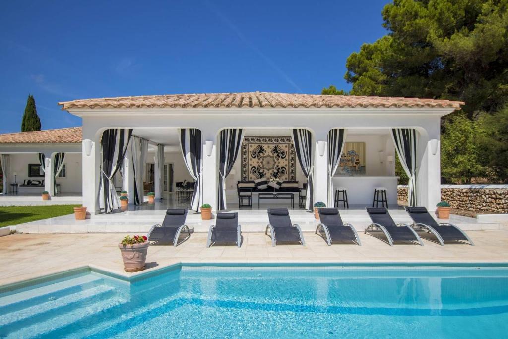 桑帕克Menorca Villa Marbella的一个带椅子的游泳池和一个凉亭