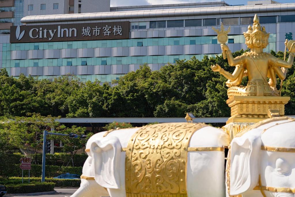 深圳有集城市客栈锦绣中华店Unijoy Cityinn Splendid China Shenzhen的一座建筑前的金象雕像