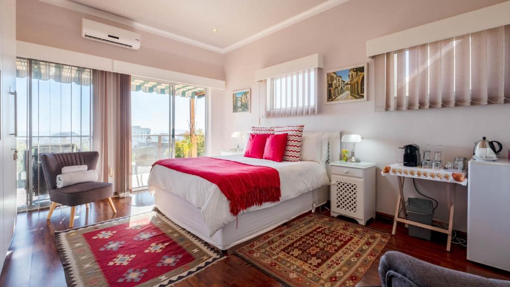 开普敦昂科贝宾馆的一间卧室配有一张带红色枕头的大床