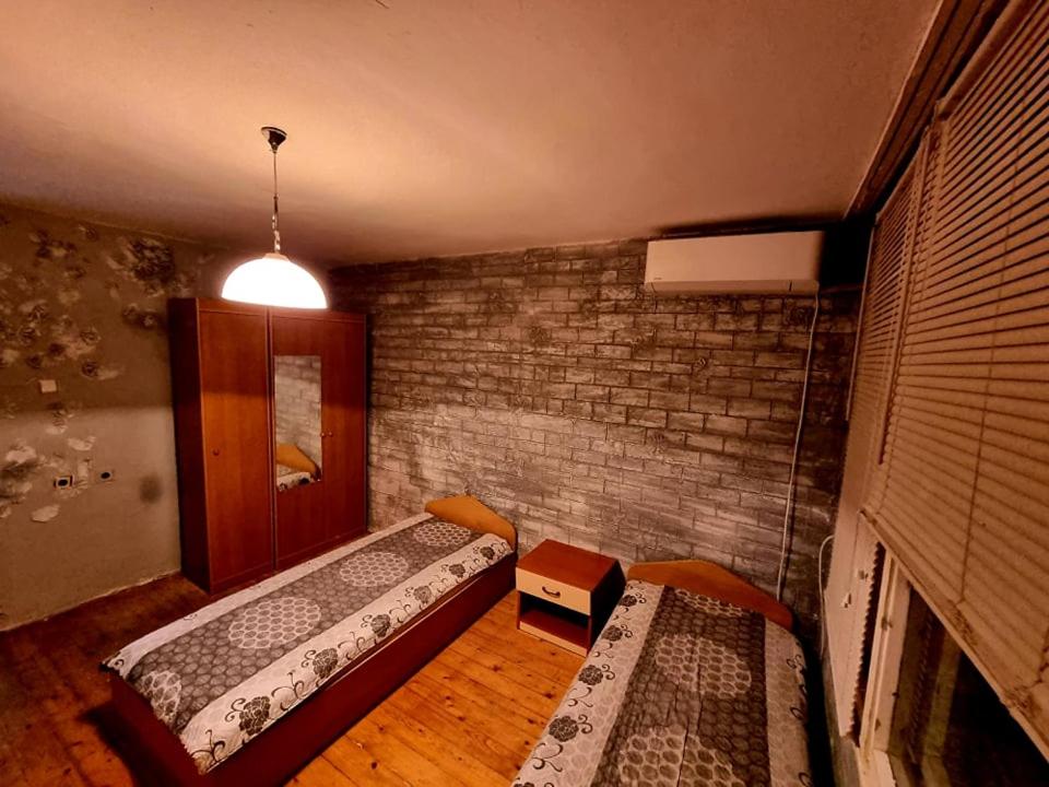 Razgradтри стаен лукс апартамент的一间设有两张床和砖墙的房间