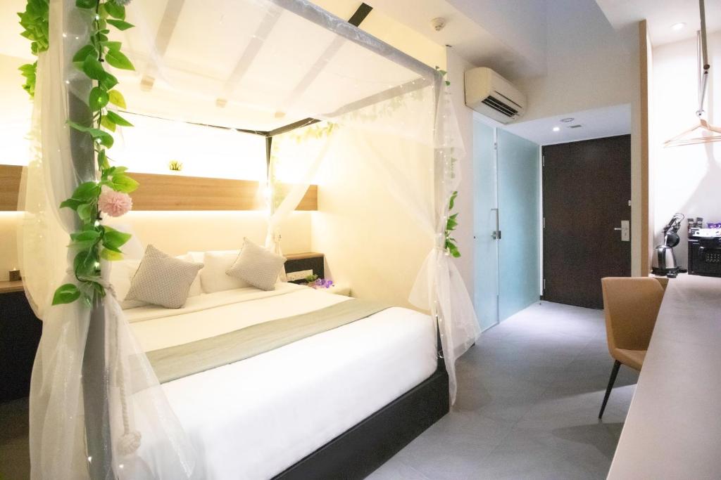 新加坡Hotel NuVe的一间卧室配有一张带天蓬的床