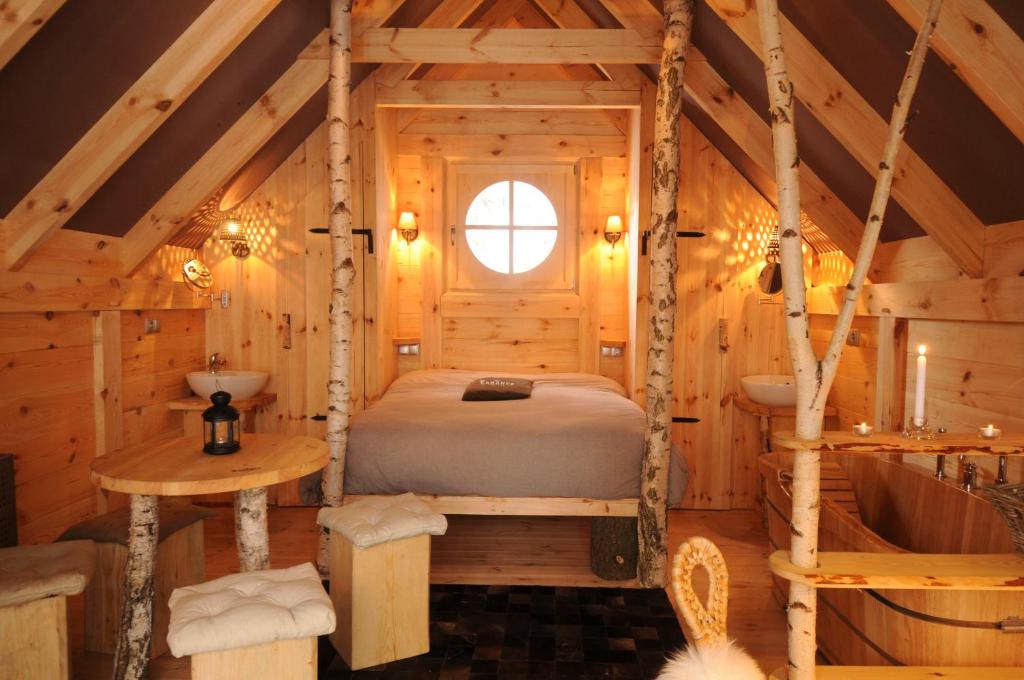 米罗勒莱克尚邦小屋酒店的小木屋内的卧室配有床和浴缸