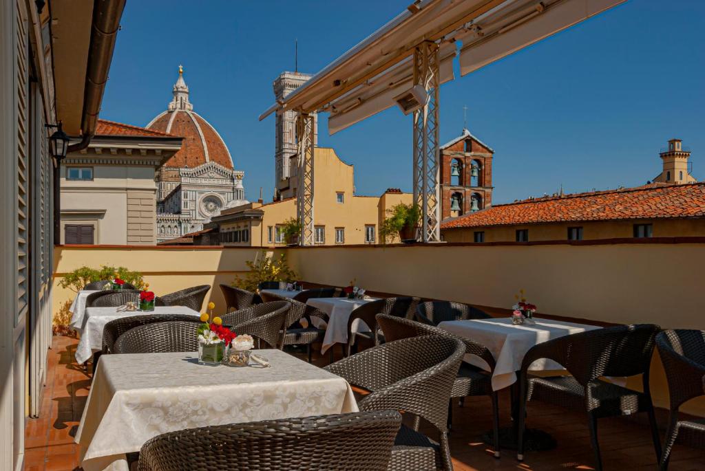 佛罗伦萨B&B Hotel Firenze Laurus Al Duomo的阳台餐厅,配有桌椅