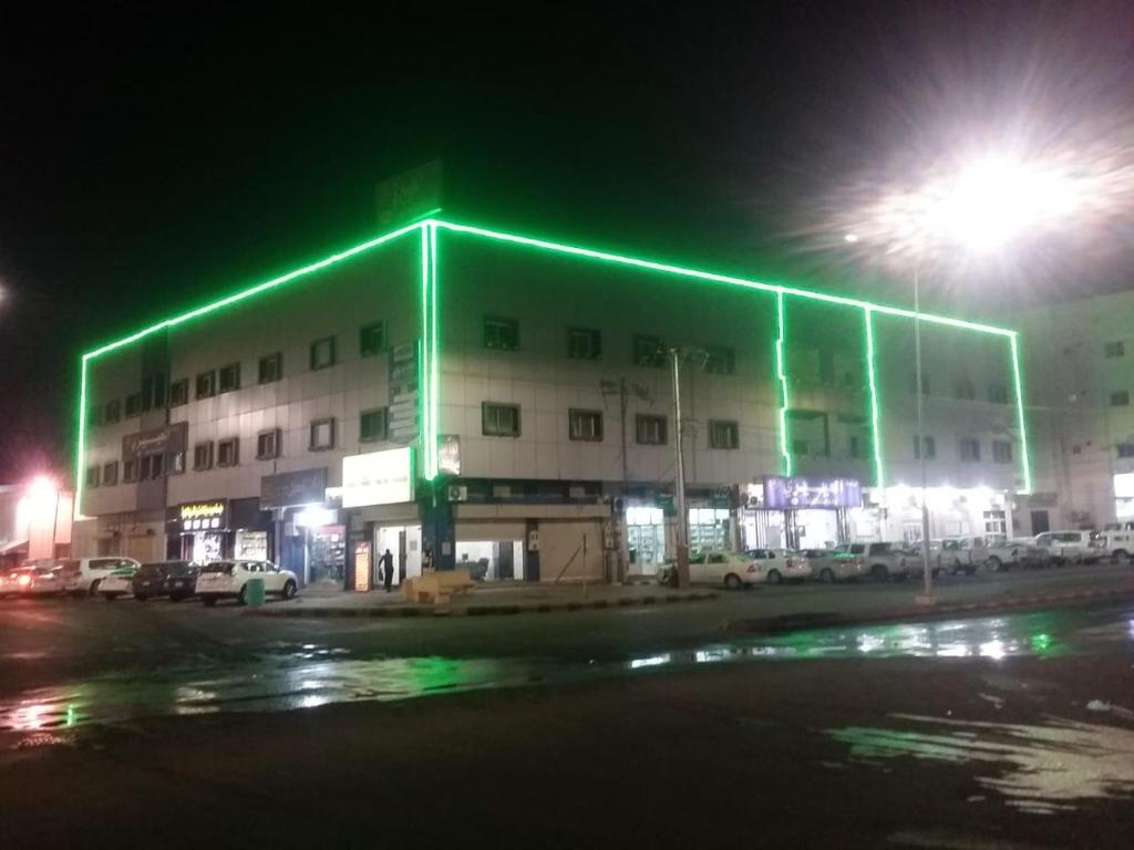 哈伊勒العييري للشقق المفروشة حائل 3的一座在晚上有绿灯的大建筑