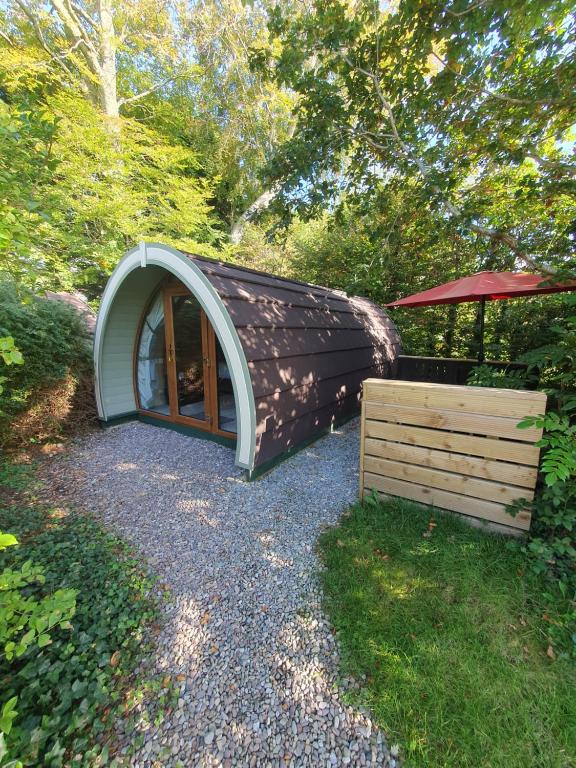基拉尼Priory Glamping Pods and Guest accommodation的一个小圆顶房子,设有门和木箱