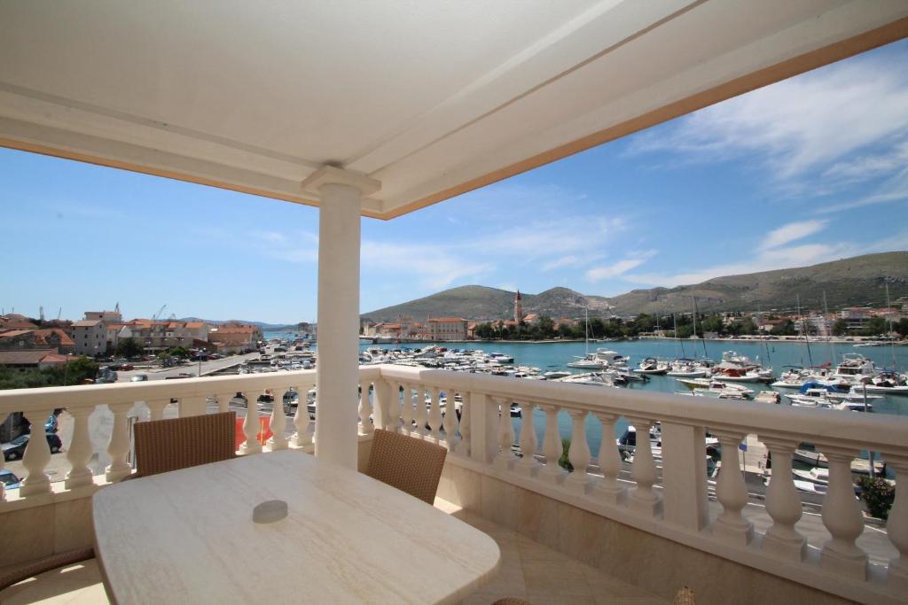 特罗吉尔特洛吉尔宫殿酒店的阳台配有桌子,享有码头的景致。