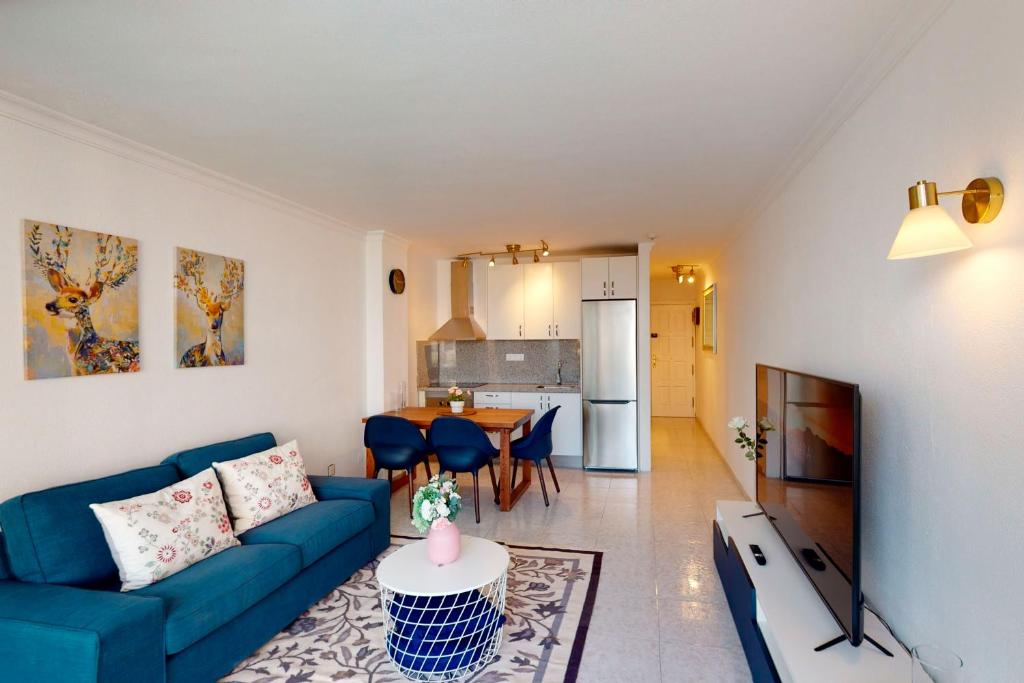 英格兰海滩Sunny Apartment Tanife by Yumbo的客厅配有蓝色的沙发和电视