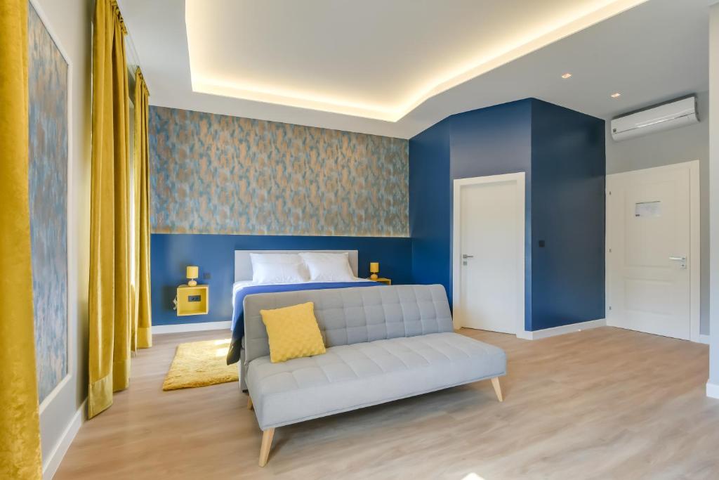 萨格勒布Royal residence Zagreb的一间卧室设有蓝色的墙壁和一张沙发