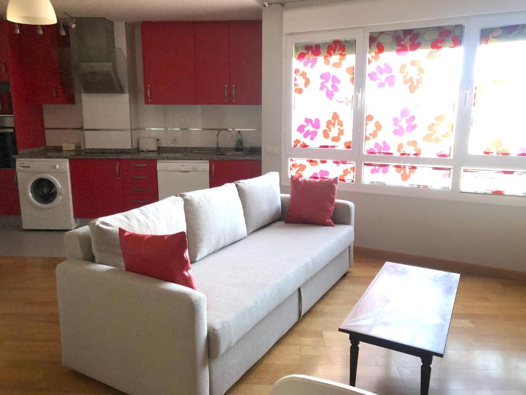 塞哥维亚诺露纳公寓的客厅配有白色沙发和红色枕头。
