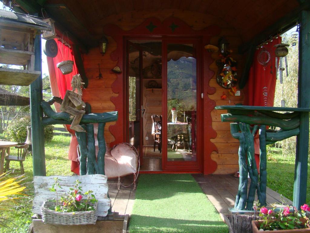 YenneLes Patins à Roulottes的小木屋,设有红色的门和一些植物