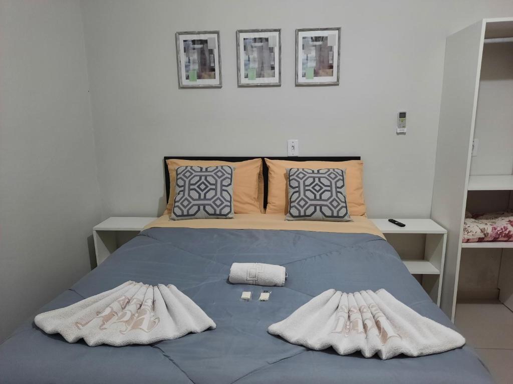 阿雷格里港Hotel Três Passos - Prox ao Aeroporto e Rodoviária的一间卧室配有蓝色的床和两个枕头