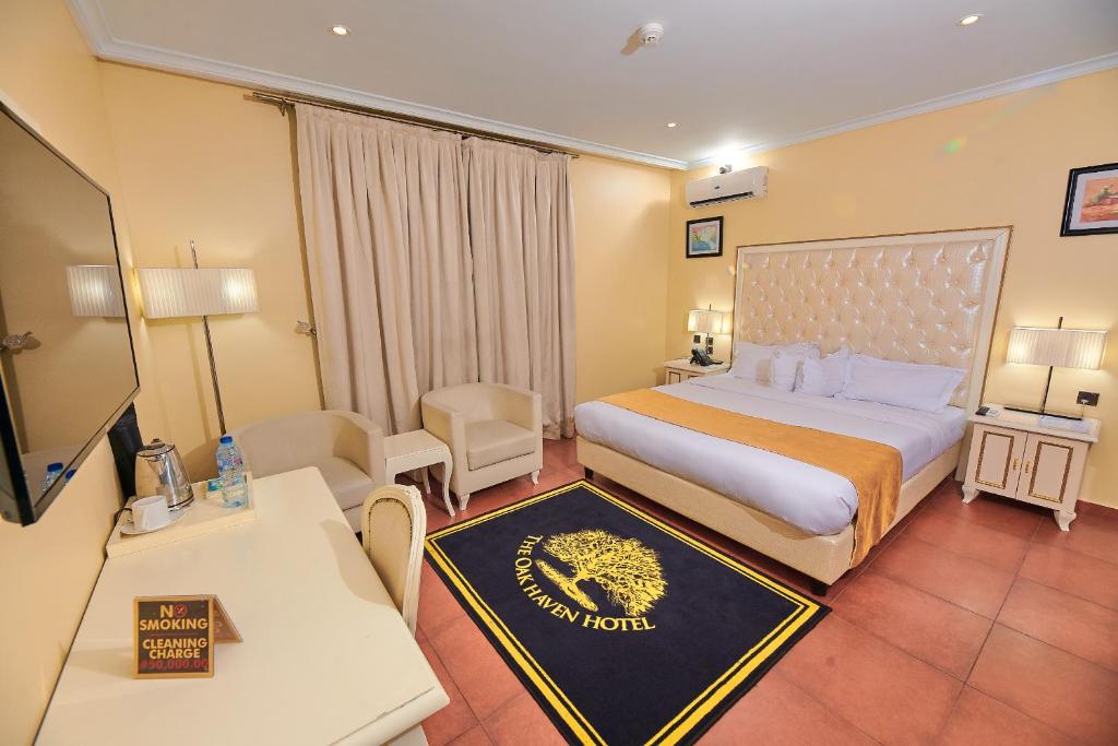 哈科特港Oak Haven Hotel & Suites的酒店客房配有一张特大号床和一张沙发。
