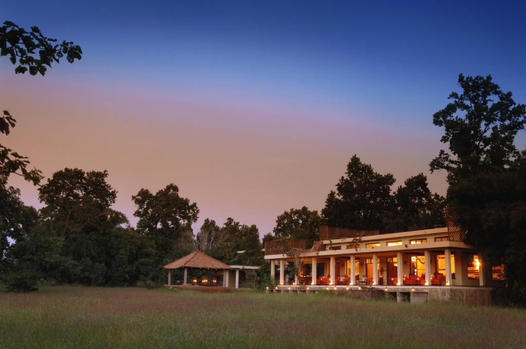 塔拉Mahua Kothi Bandhavgarh - A Taj Safari Lodge的一座大建筑,在田野上设有凉亭