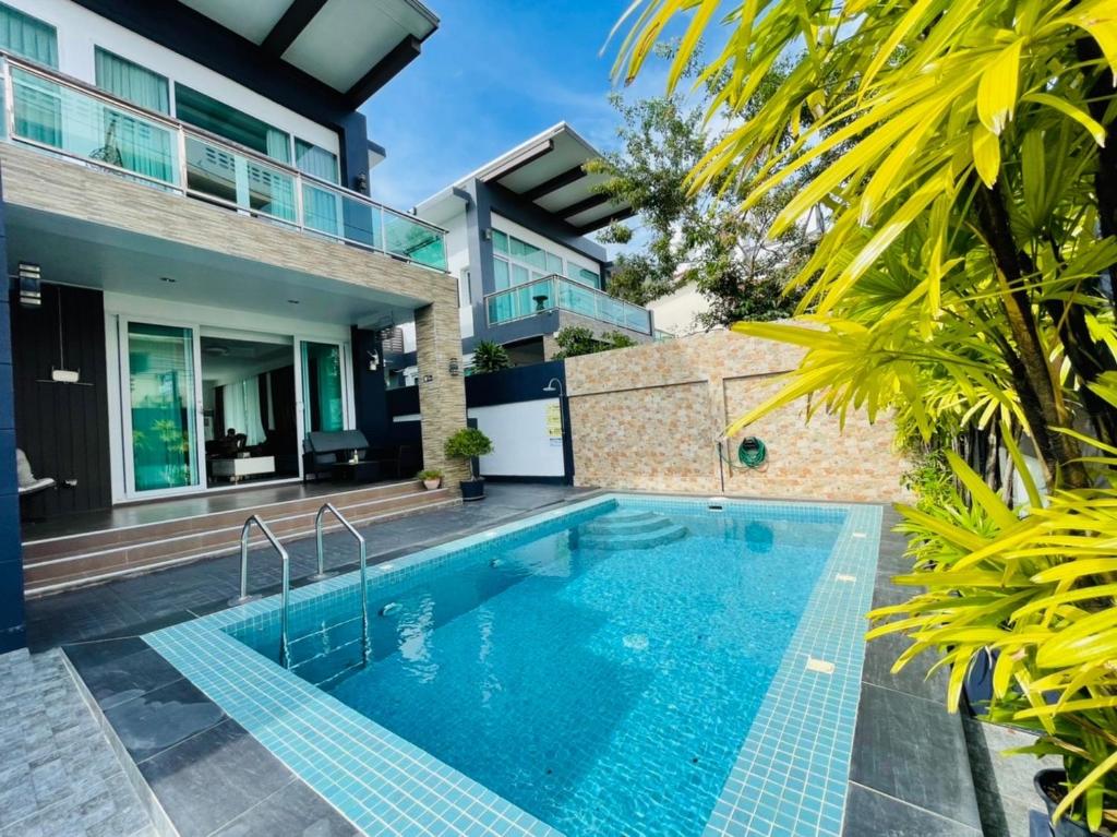 芭堤雅市中心KW pool villa pattaya的一座房子后院的游泳池