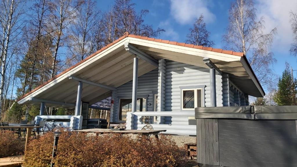 耶姆赛Järvenrantamökki Himoksella poreammeella的小型白色小屋,设有倾斜的屋顶