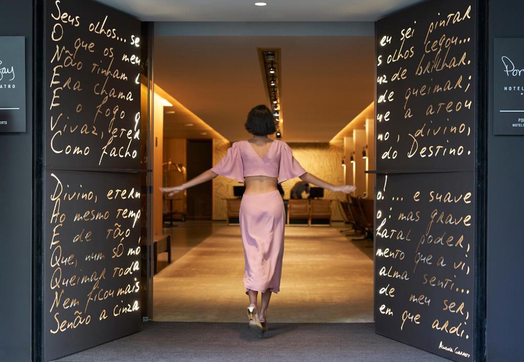 波尔图PortoBay Teatro的模特穿着粉红色的衣服沿着走廊走