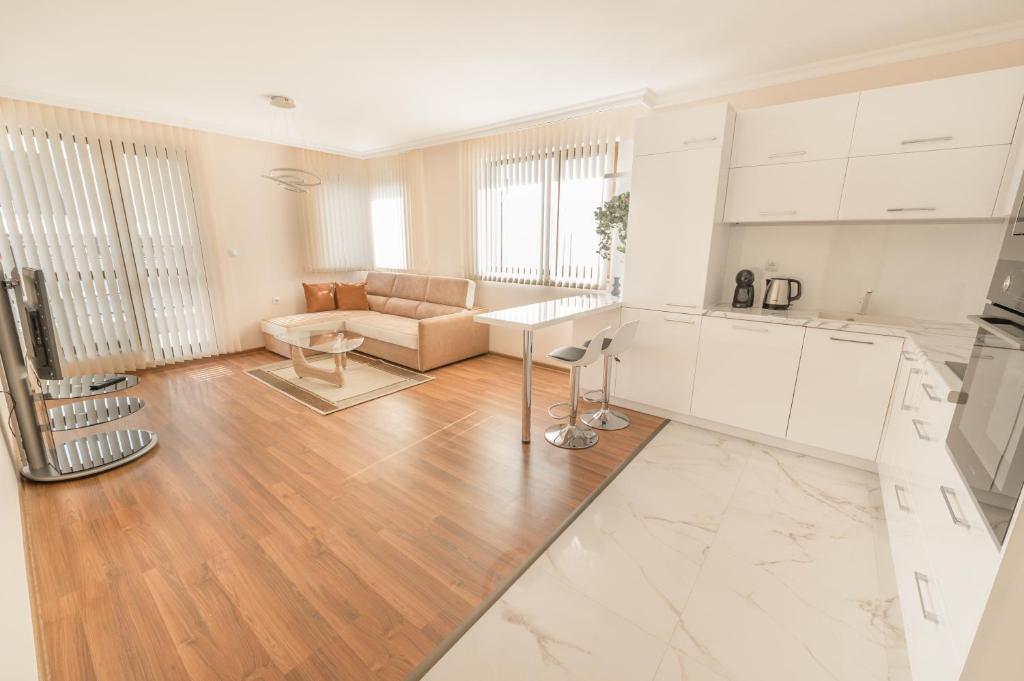 普罗夫迪夫Etica Apartments的厨房以及带白色橱柜的客厅。