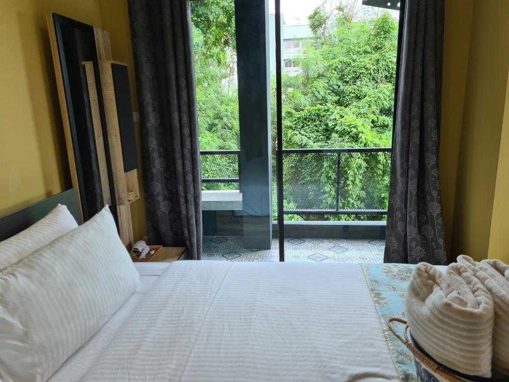 Ban Song HongThe Lantern Suites的一间卧室设有一张床和一个大窗户