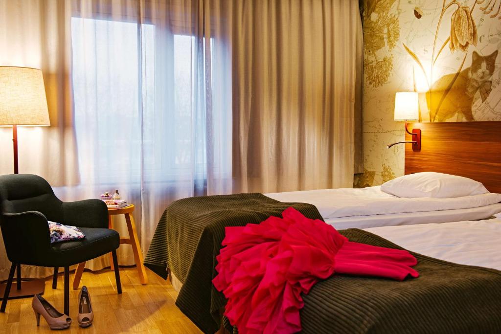 耶夫勒斯堪迪克加弗勒瓦斯特酒店的一间酒店客房,床上穿红色连衣裙