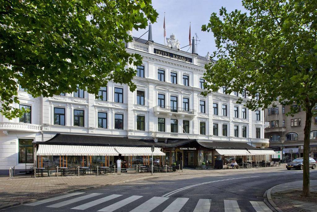 马尔默斯堪迪克克莱默酒店的前面有桌椅的白色建筑