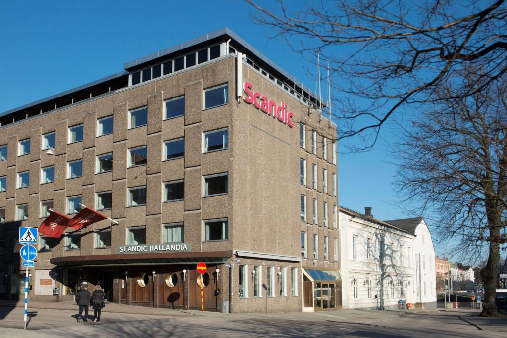哈尔姆斯塔德斯堪迪克哈兰迪尔酒店的一座高大的建筑,旁边有一个标志