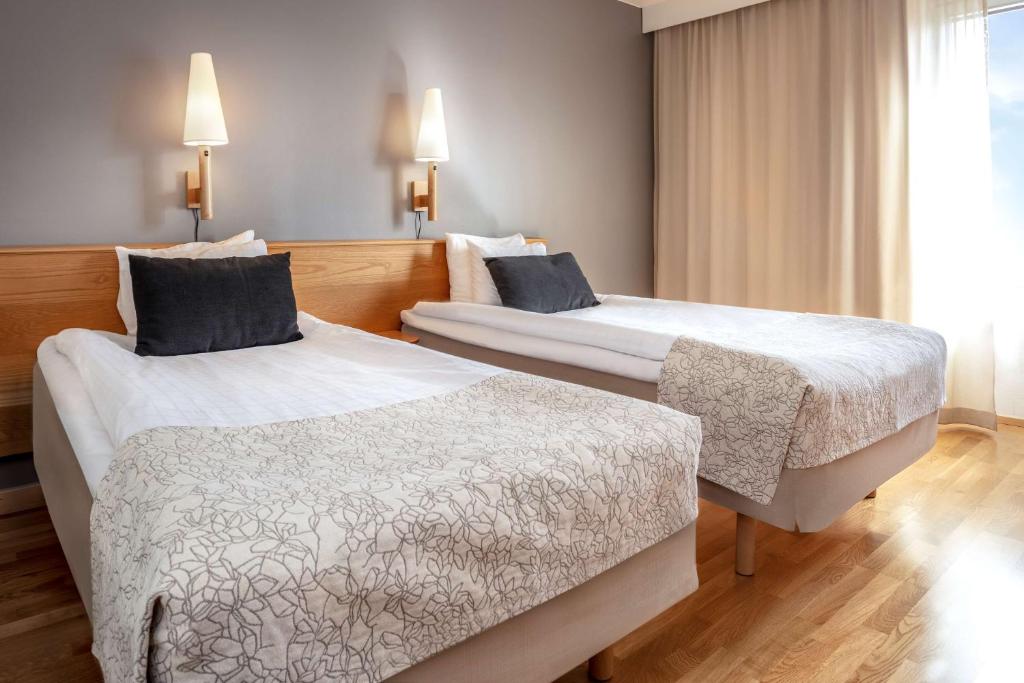 延雪平斯堪迪克波塔伦酒店的酒店客房设有两张床和窗户。