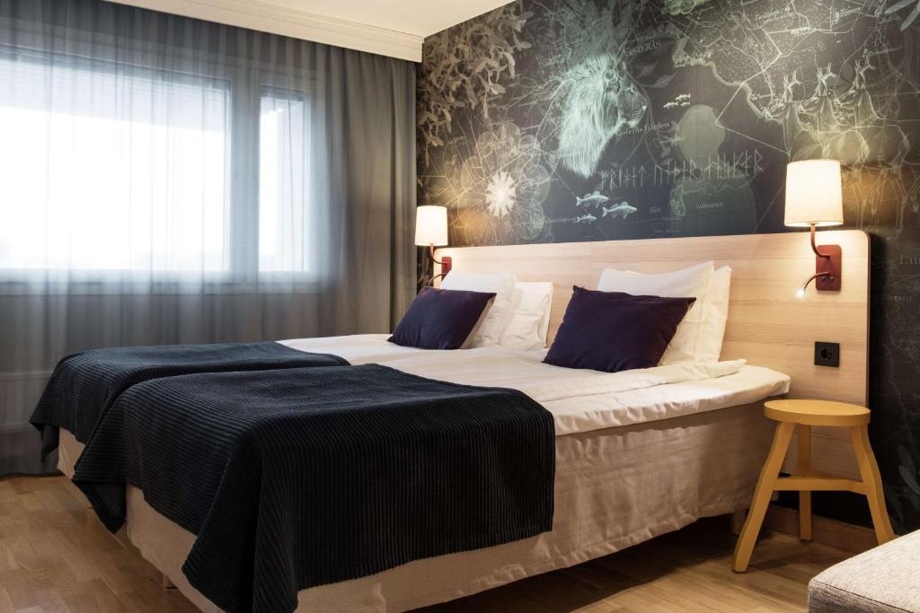 韦斯特罗斯瓦斯特拉斯堪迪克酒店的酒店客房配有一张带蓝色枕头的大床